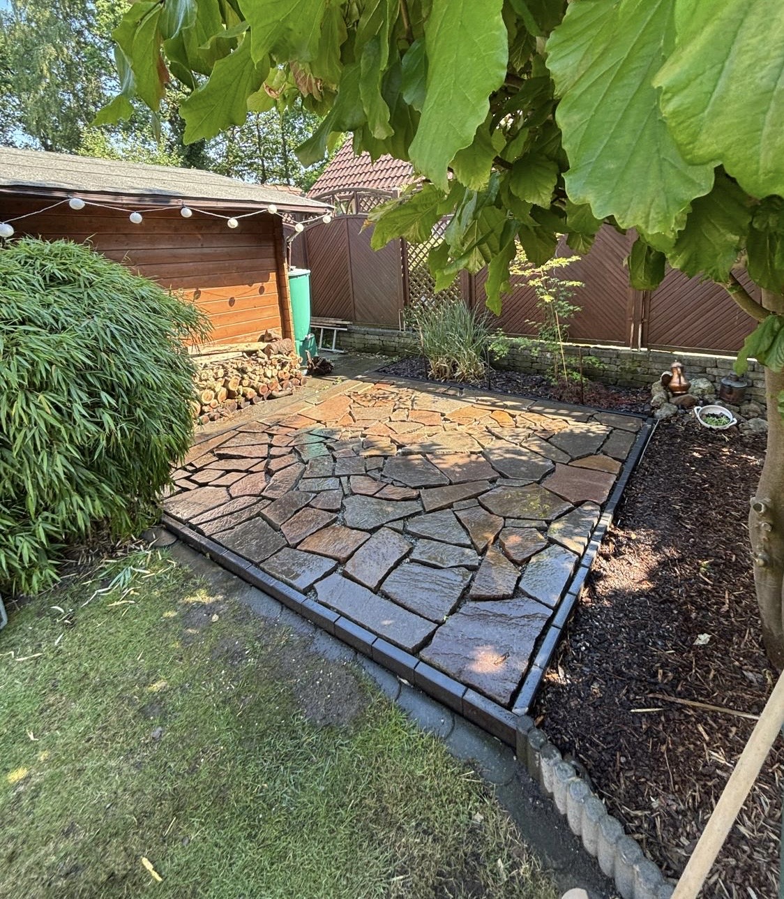 Frisch verlegte Polygonalplatten aus Naturstein, noch feucht vom Einschlämmen